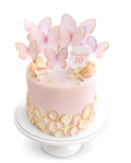 Butterfly themed blush pink cake with gold accents and delicate butterfly decorations finished in white chocolate ganache on white cake stand