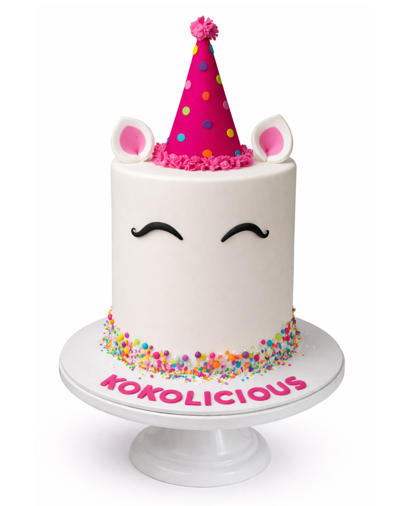 Unicorn themed birthday cake with party hat, sprinkles and minimal white finish on white cake stand