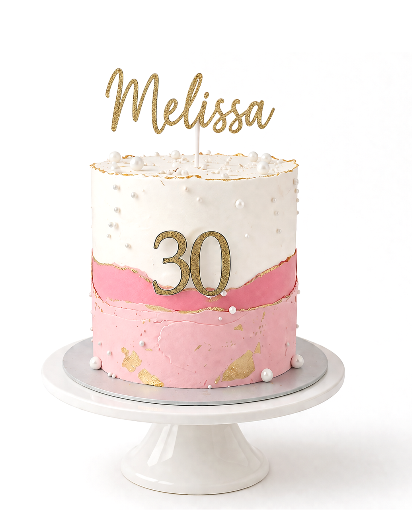 Elegant pink and white cake with pearl accents and gold detailing finished in white chocolate ganache on white cake stand