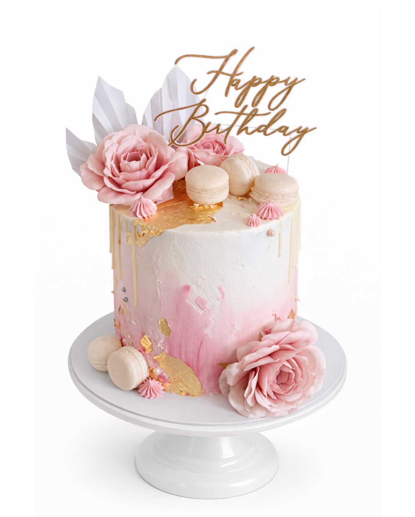 Elegant pink floral cake with gold leaf detailing, macarons and rose decorations finished in white chocolate ganache on white cake stand